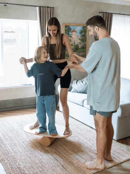 Kind balanciert auf dem Balance Board aus Holz