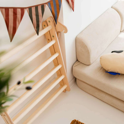 Faltbares Kletterset Panda mit Kletterbogen und Sofaecke im Raum, ideal für Kinder zum Spielen.