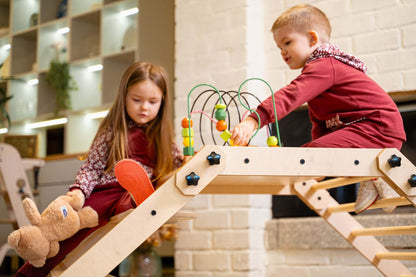 Kinder spielen aktiv am Klettertisch NABU in einem hellen Raum
