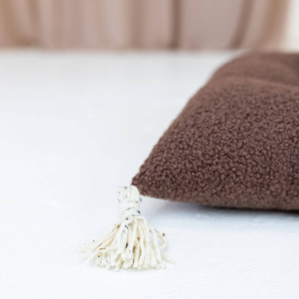 Detailansicht des Bouclé-Kissens für die Holzwippe in Braun