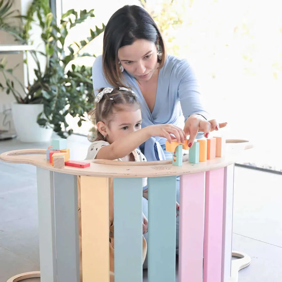 Pastellfarbener Montessori Kletterbogen als Wippe genutzt