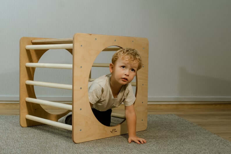 Kletterwürfel versch. Farben für Kinder, spielender Junge klettert durch Kletterwürfel im Spielzimmer.