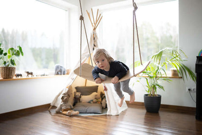 Kind balanciert auf dem Swingboard aus Holz