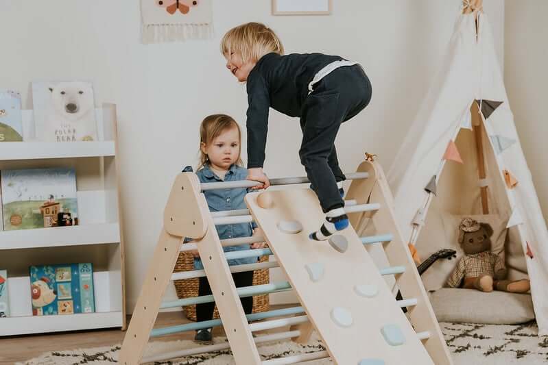 Kleinkind spielt frei am Pikler Kletterdreieck nach Pikler und Montessori