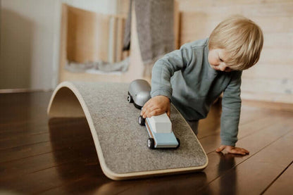 Kind balanciert auf dem Balance Board aus Holz