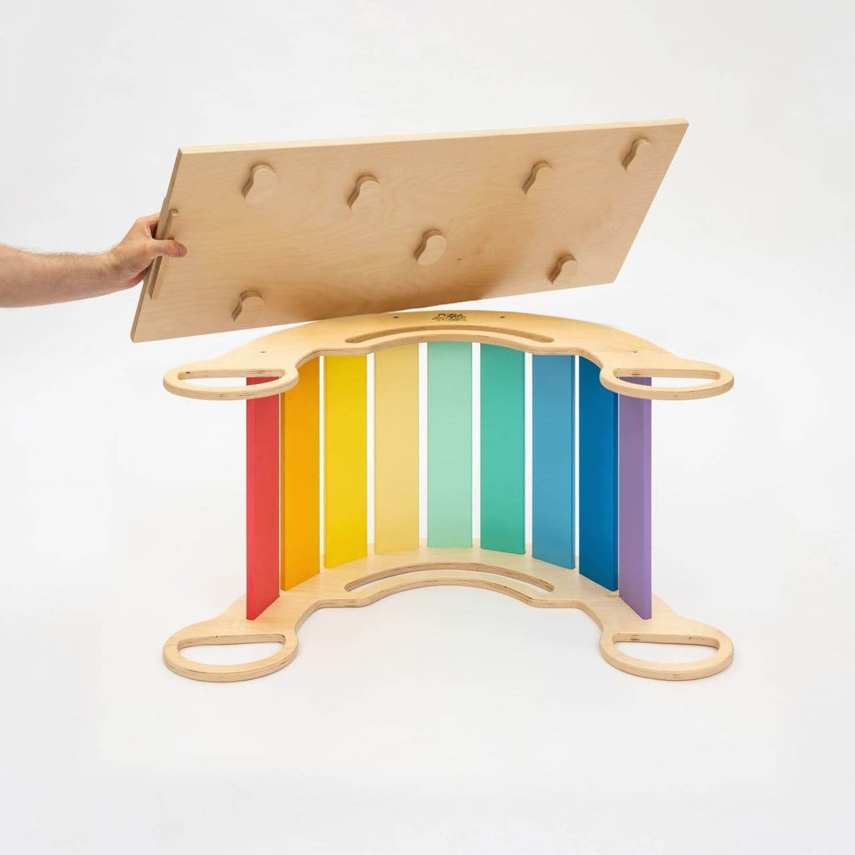Kind spielt am bunten Montessori Kletterbogen mit Rutsche